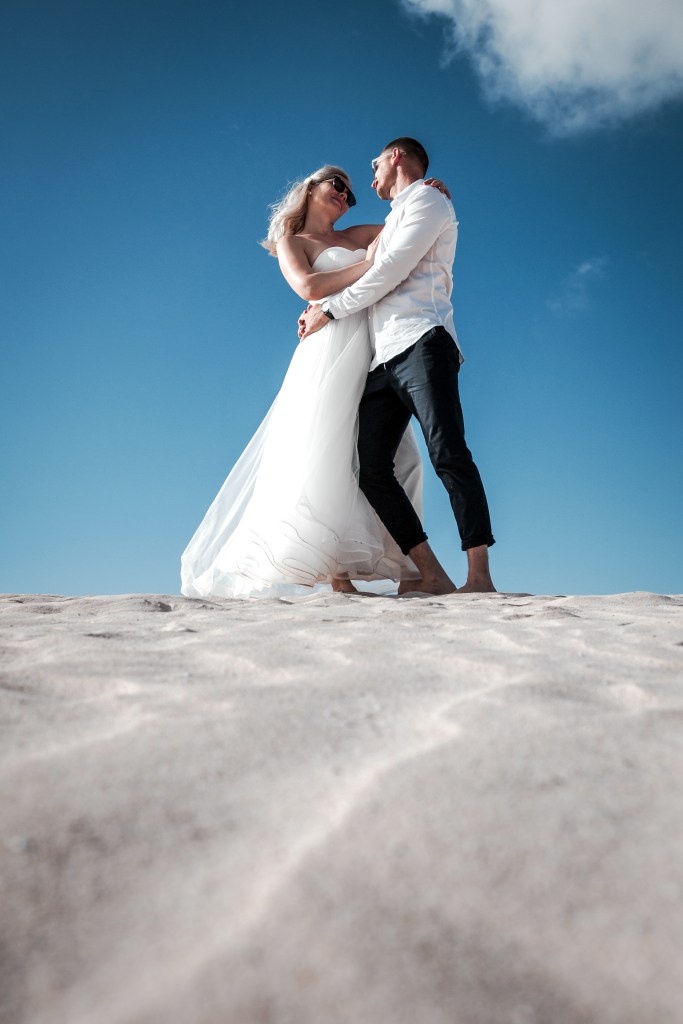 Post-Hochzeits-Fotoshoot an den Grandes Playas – Brautpaar läuft durch Fuerteventuras Dünen mit Top-Hochzeitsfotograf