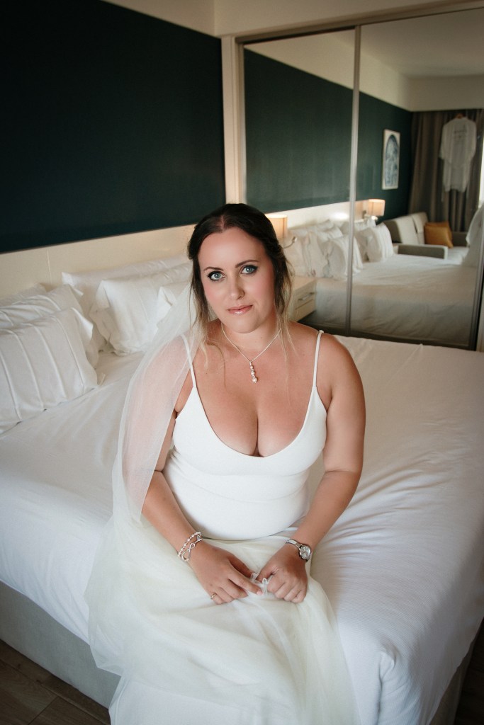 LGBTQ+ wedding in Fuerteventura - two brides exchange vows under floral arch as celebrant officiates, captured by best wedding photographer