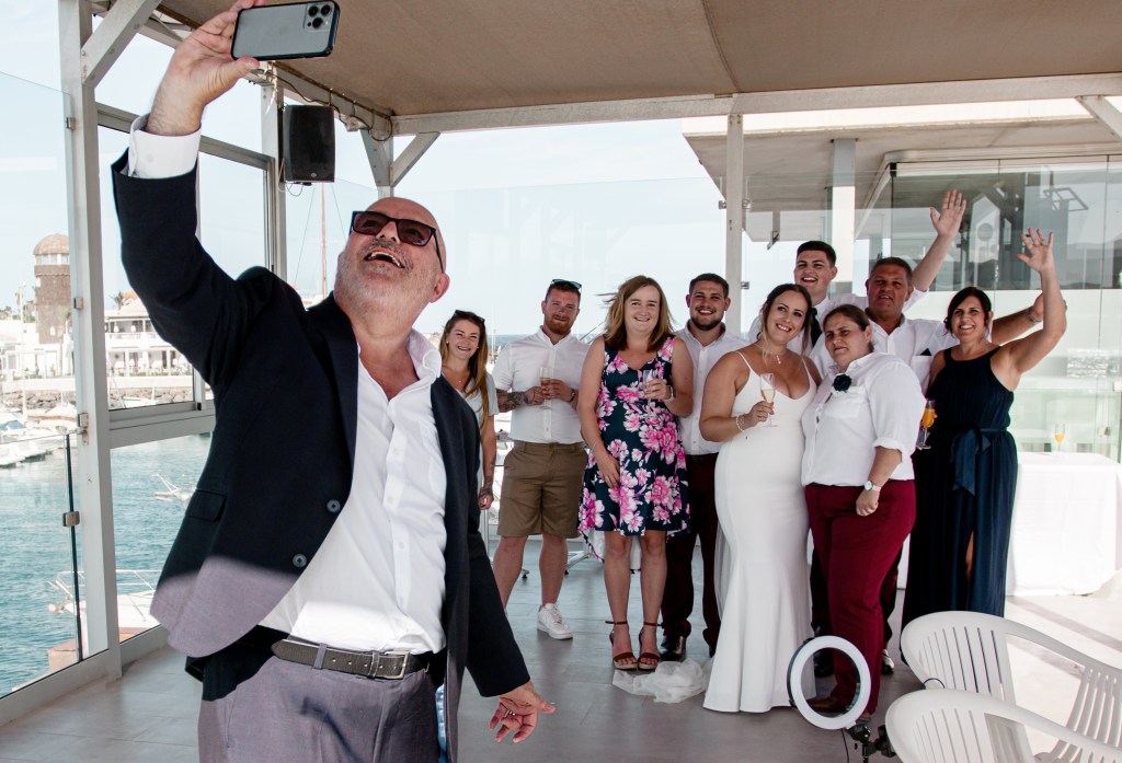 Proud LGBTQ+ wedding photography - brides celebrate marriage equality with celebrant under floral canopy, Fuerteventura's best photographer capturing joy