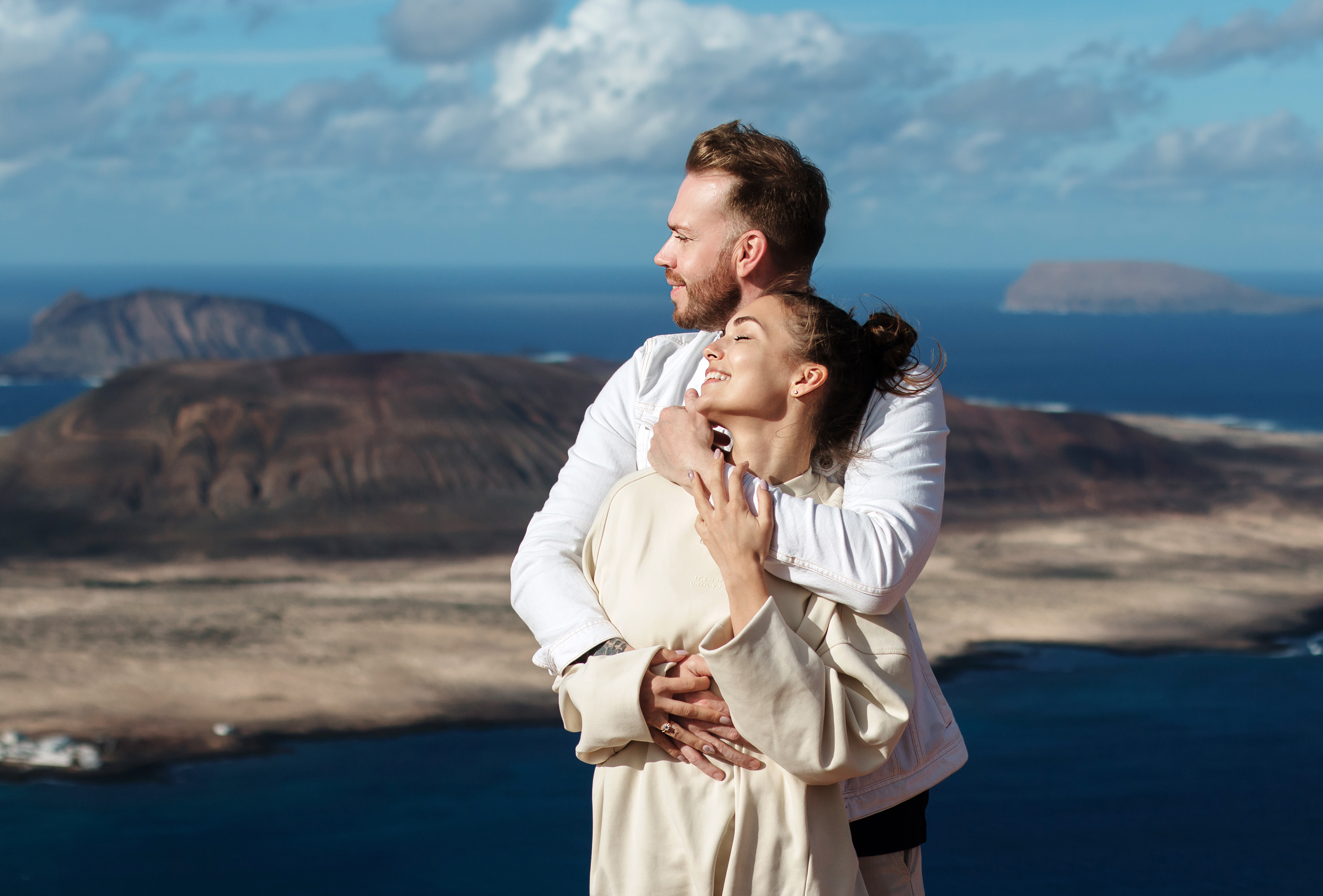 Una pareja se para en el acantilado del Mirador del Río en Lanzarote con vistas a la isla de La Graciosa mientras el fotógrafo de Lanzarote hace una sesión de fotos