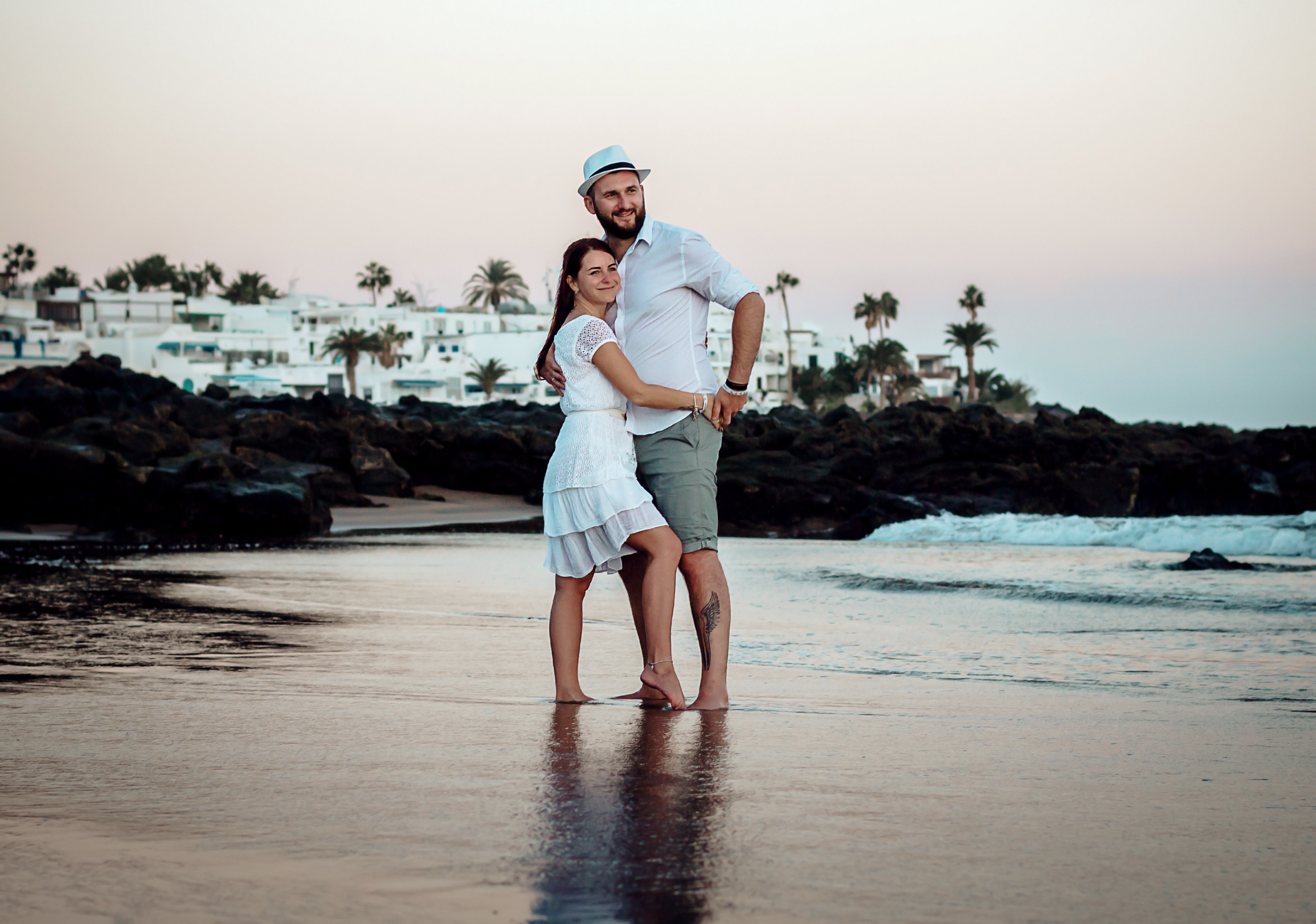 Der Hochzeitsfotograf auf Lanzarote macht Fotos von Braut und Besen in goldenen Stunden an einem Strand von Puerto del Carmen