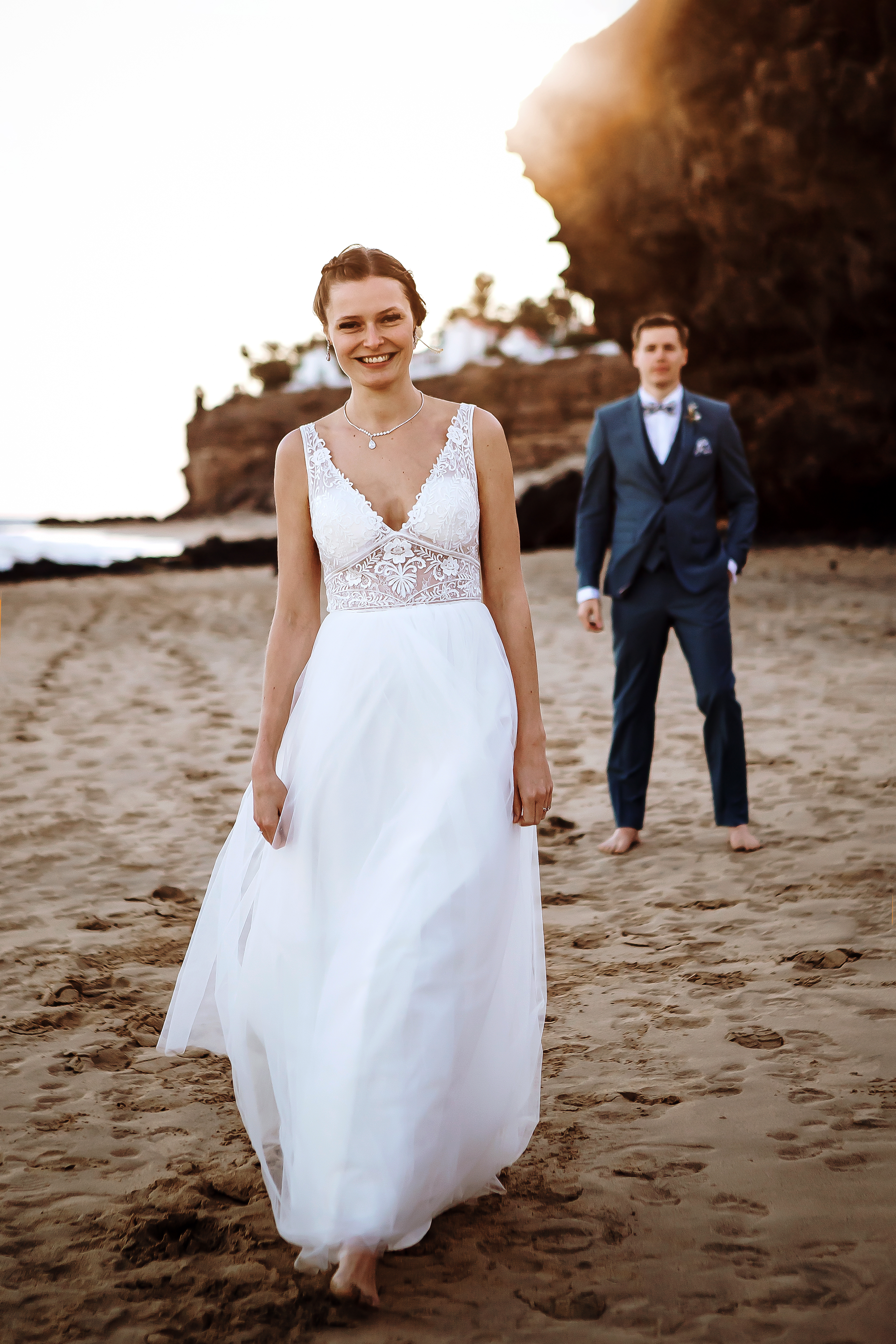 Bride is looking to a wedding photographer in Fuerteventura while groom stands a little away from the scene