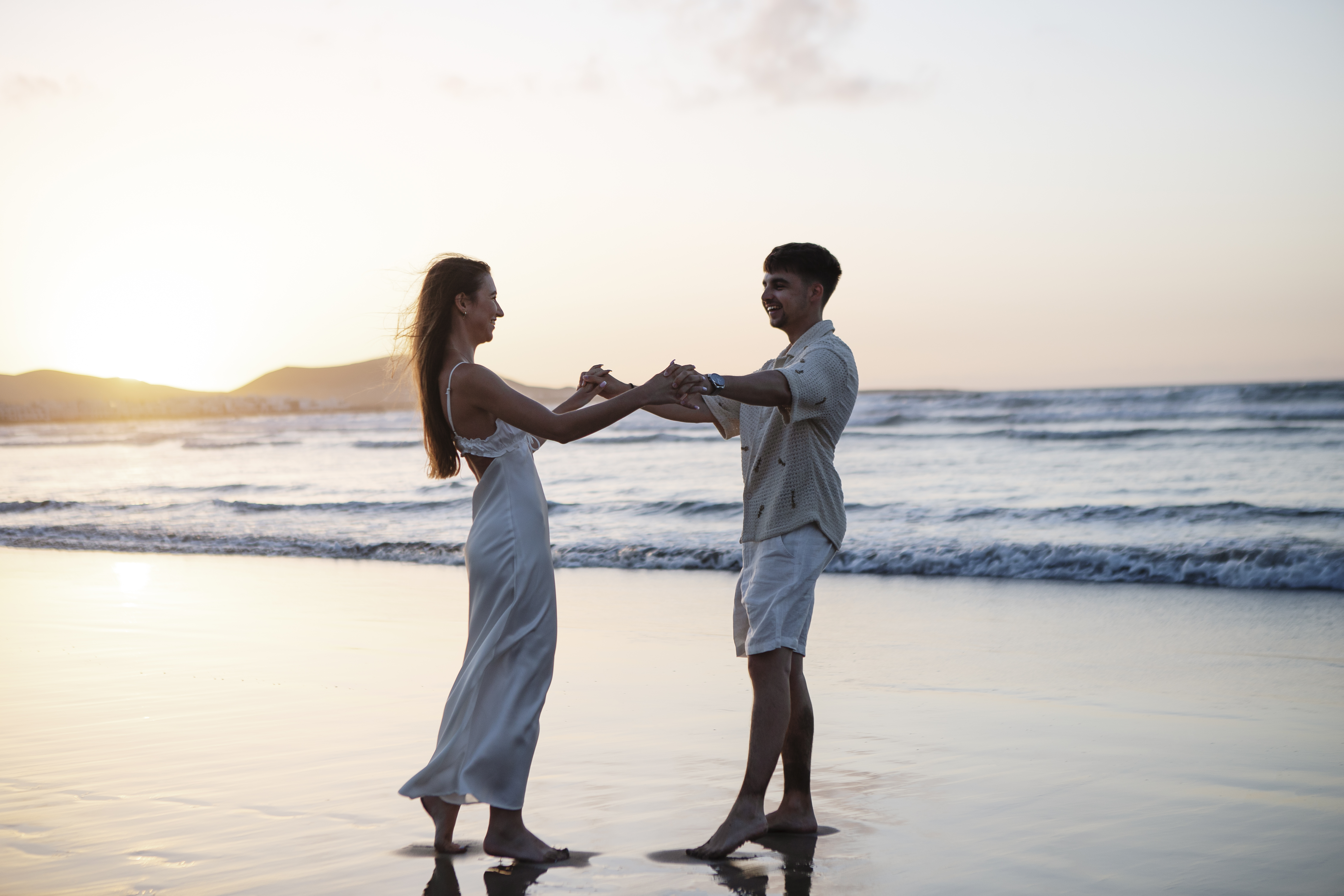 Couple enjoying a sunset proposal on Famara beach in Lanzarote – proposal photographer in Lanzarote capturing the magical moment