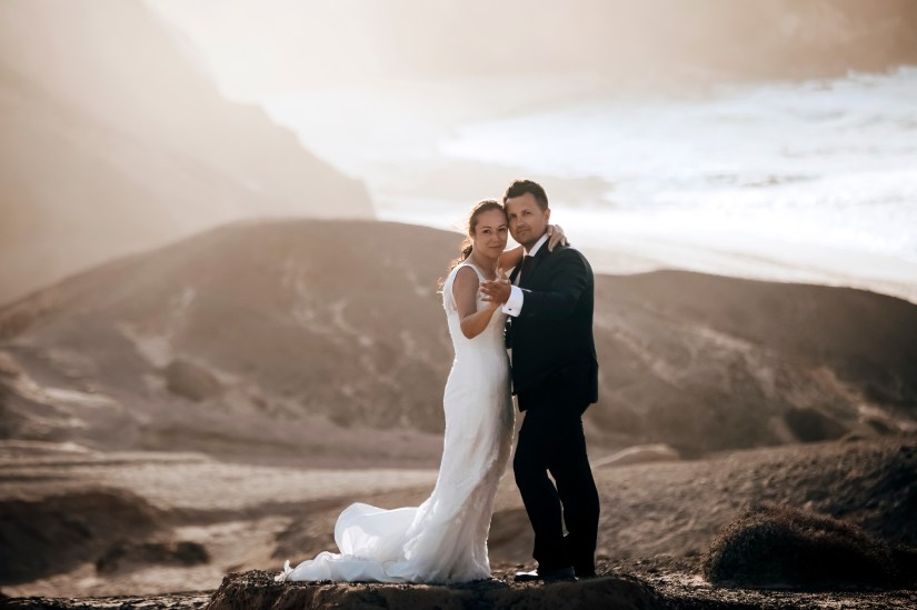 Pareja recién casada compartiendo un abrazo al atardecer en la playa de La Pared – fotografía romántica post-boda en Fuerteventura