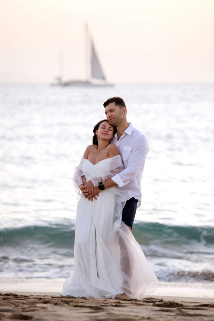 Emotioneel moment: bruid en groom knuffelen aan de turquoise zee van Playa Papagayo - elopement fotograaf