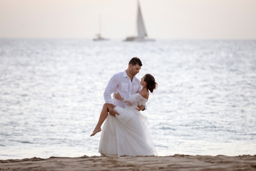 Avontuurlijke trouwfoto's op Playa Papagayo: koppel geniet van intiem moment aan het water