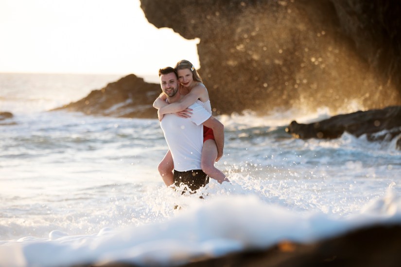 Couple standing in the ocean at sunset during their elopement in Fuerteventura – romantic golden hour beach photography